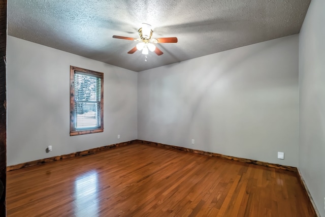 spare room featuring ceiling fan, wood-type flooring, and a textured ceiling