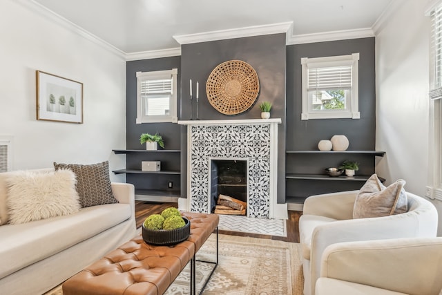 living room with a tile fireplace, crown molding, and wood-type flooring