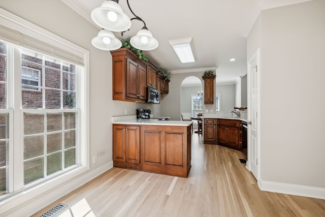 kitchen featuring kitchen peninsula, light wood-type flooring, ornamental molding, black appliances, and pendant lighting