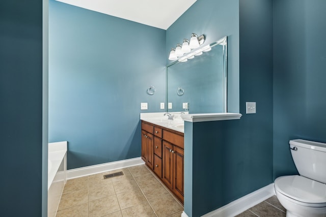 bathroom with tile patterned floors, a bathtub, vanity, and toilet