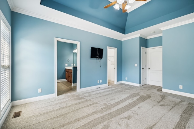 unfurnished bedroom with light carpet, ensuite bath, and ceiling fan