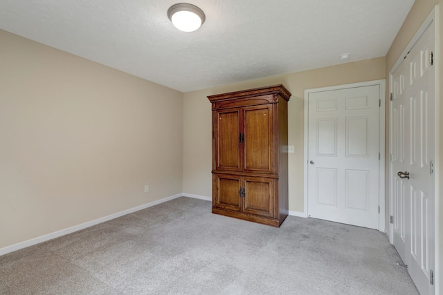 unfurnished bedroom with light carpet and a textured ceiling