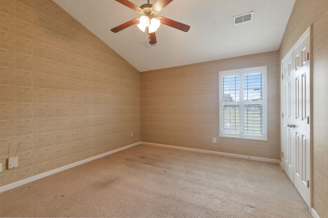 empty room featuring light carpet, ceiling fan, and lofted ceiling