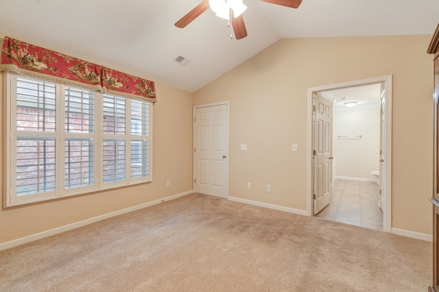 unfurnished bedroom with light carpet, ensuite bathroom, ceiling fan, and lofted ceiling