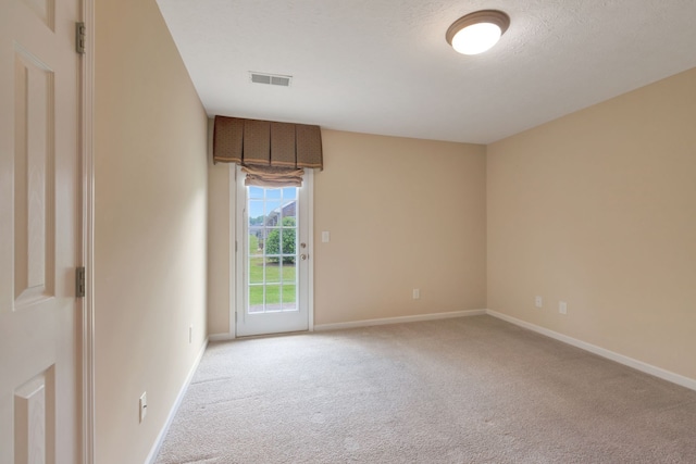 carpeted spare room with a textured ceiling