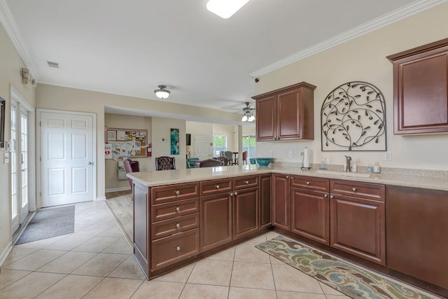 kitchen featuring kitchen peninsula, light tile patterned floors, crown molding, and sink