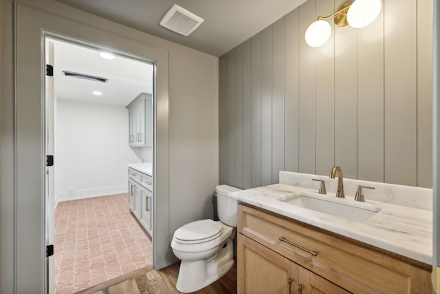 bathroom with vanity, toilet, and wood-type flooring