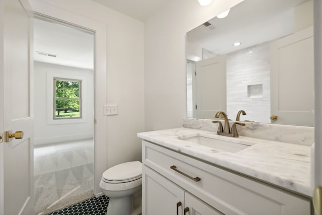 bathroom with tile patterned flooring, vanity, and toilet