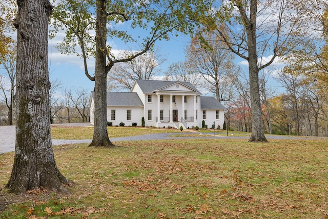 neoclassical / greek revival house featuring a front lawn and covered porch