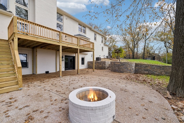 view of patio with a fire pit, cooling unit, and a deck