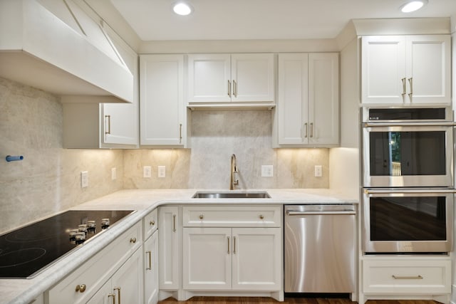 kitchen with sink, white cabinetry, stainless steel appliances, and tasteful backsplash