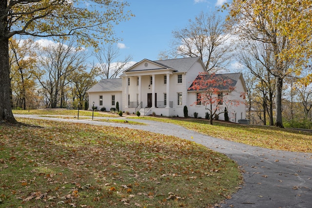 neoclassical home featuring a front yard