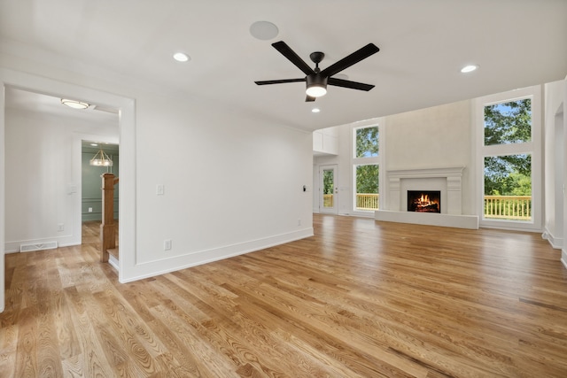 unfurnished living room featuring light wood-type flooring, plenty of natural light, and ceiling fan