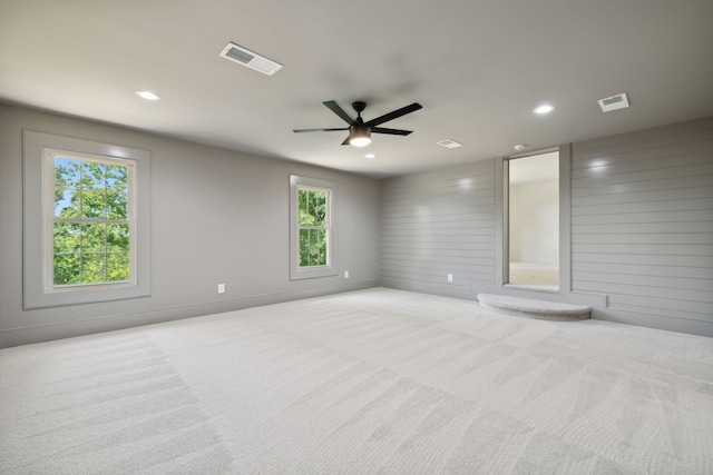 carpeted empty room with ceiling fan and a healthy amount of sunlight