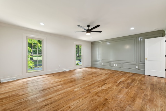 unfurnished room featuring ceiling fan, a healthy amount of sunlight, ornamental molding, and light hardwood / wood-style flooring