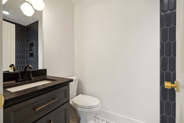 bathroom featuring tiled shower, vanity, and toilet