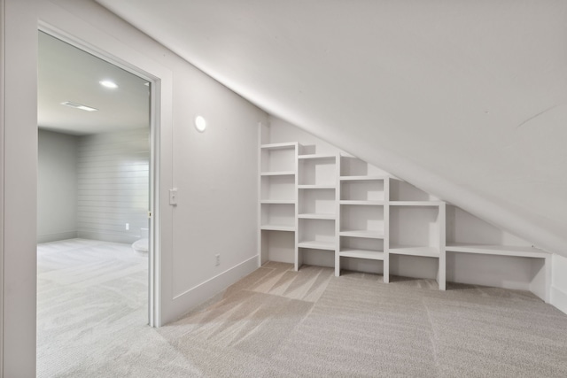 walk in closet featuring light colored carpet and vaulted ceiling