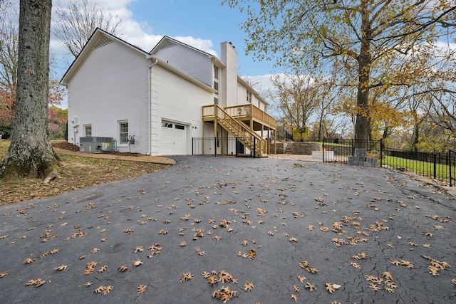 view of property exterior featuring a garage and a wooden deck