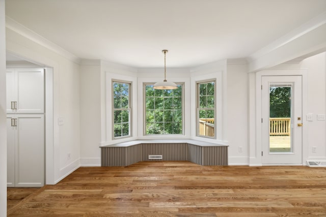 unfurnished dining area with hardwood / wood-style floors and a healthy amount of sunlight