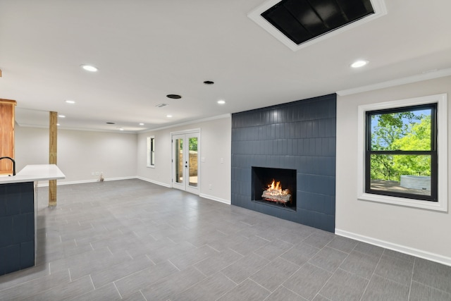 basement with a large fireplace and ornamental molding