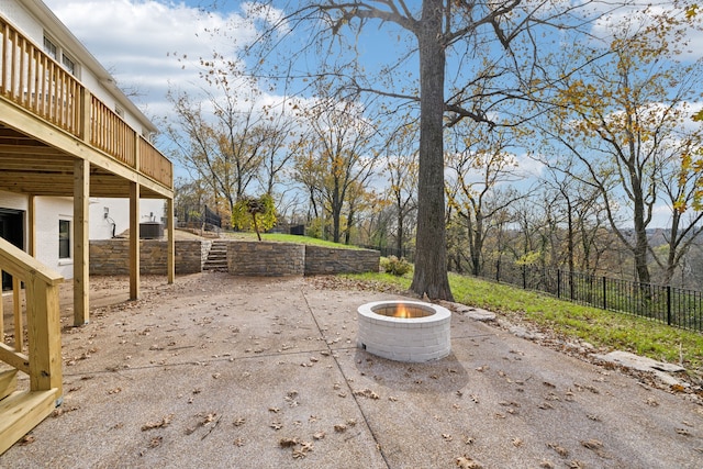 view of patio / terrace with a wooden deck and an outdoor fire pit