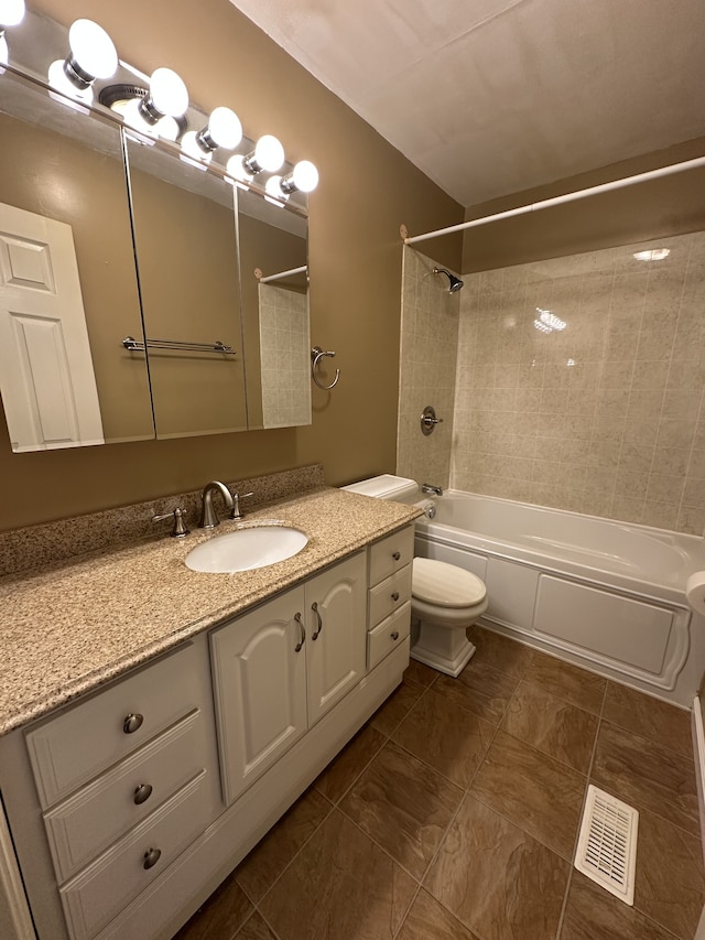 full bathroom featuring tiled shower / bath, tile patterned flooring, vanity, and toilet