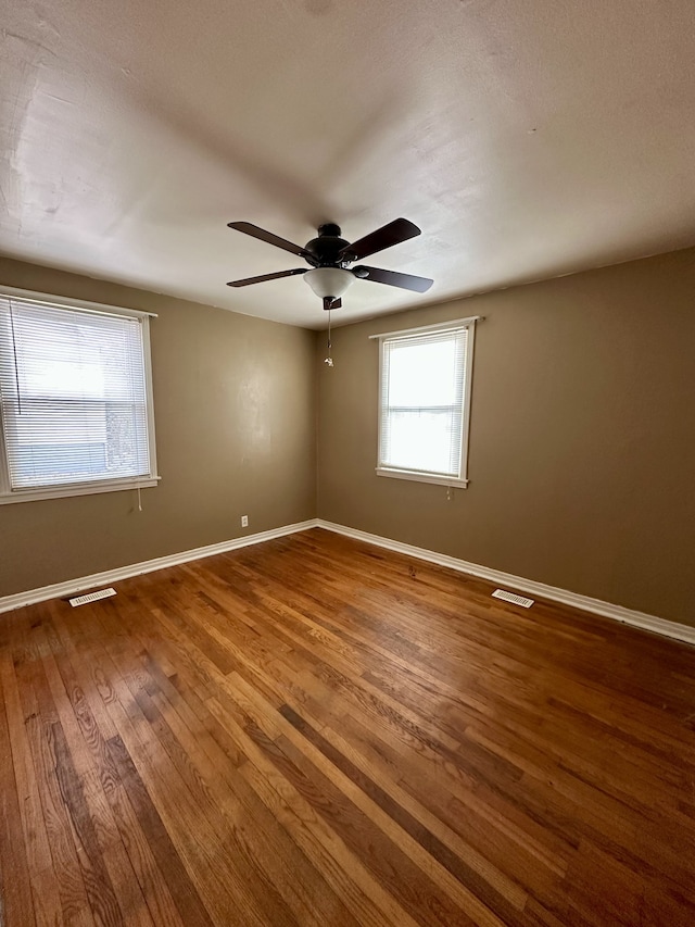 empty room featuring hardwood / wood-style flooring and ceiling fan