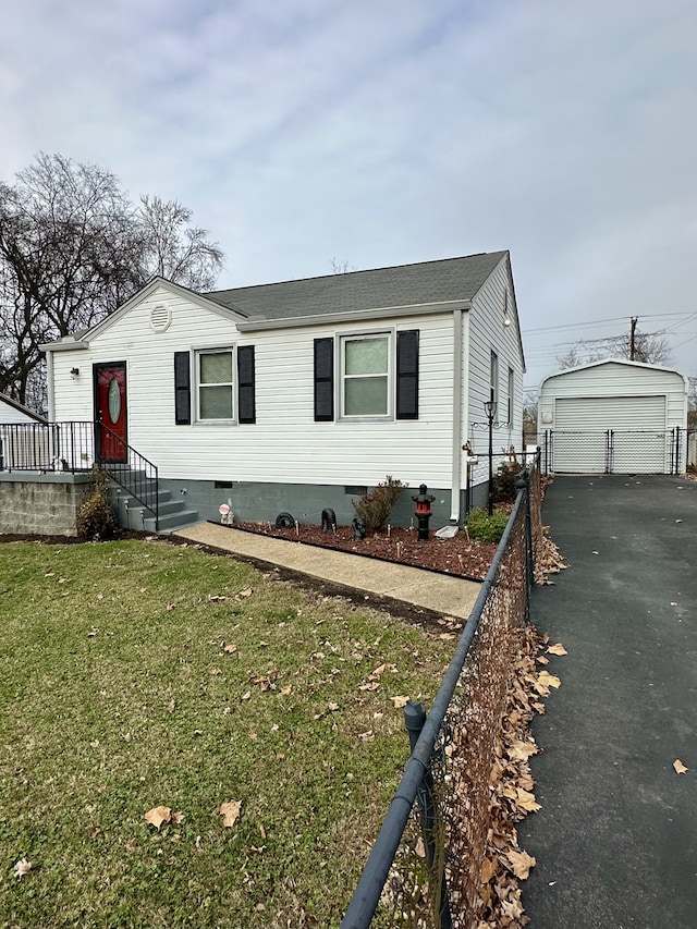 manufactured / mobile home featuring roof with shingles, a front lawn, a garage, an outdoor structure, and crawl space