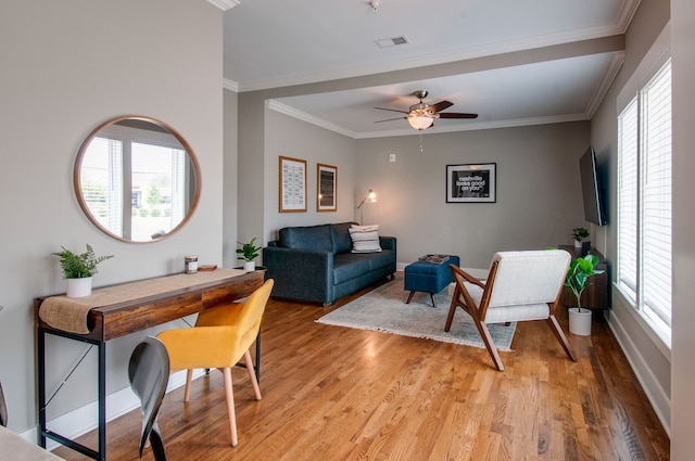 living room with light hardwood / wood-style floors, ceiling fan, and crown molding