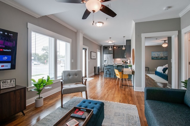 living room featuring crown molding, ceiling fan, and wood-type flooring