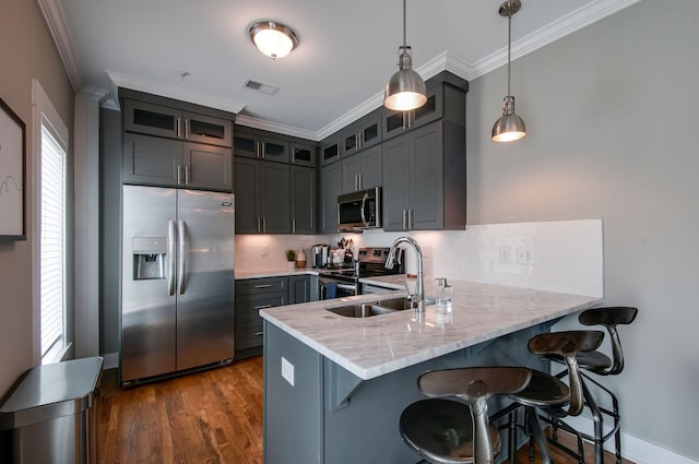 kitchen featuring pendant lighting, sink, dark hardwood / wood-style floors, tasteful backsplash, and stainless steel appliances