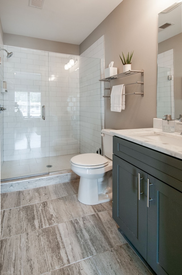 bathroom featuring toilet, vanity, and walk in shower