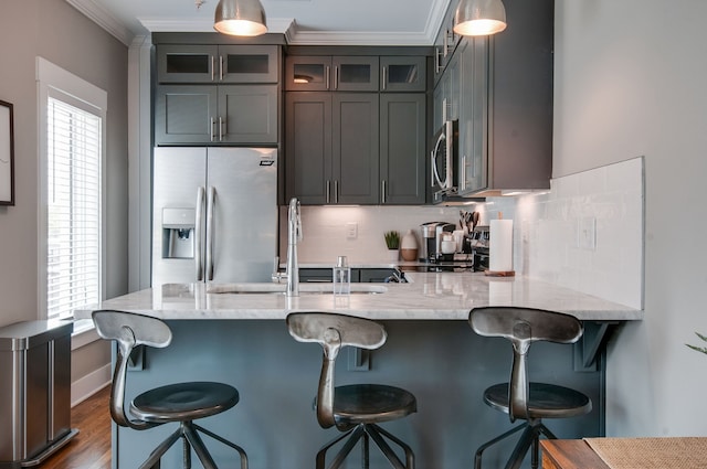 kitchen featuring pendant lighting, plenty of natural light, a kitchen breakfast bar, and appliances with stainless steel finishes