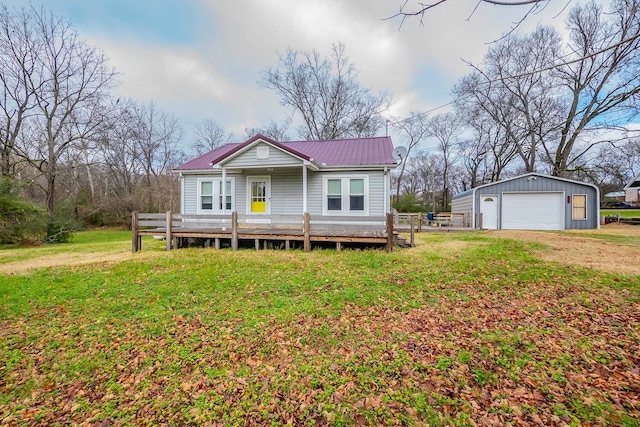 view of front of home with a garage, an outbuilding, and a front lawn