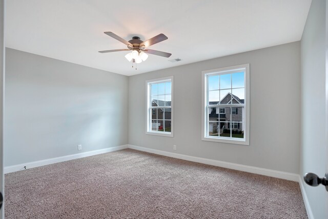 carpeted spare room featuring ceiling fan