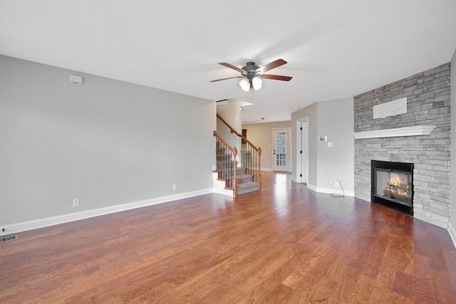 unfurnished living room with hardwood / wood-style flooring, ceiling fan, and a fireplace