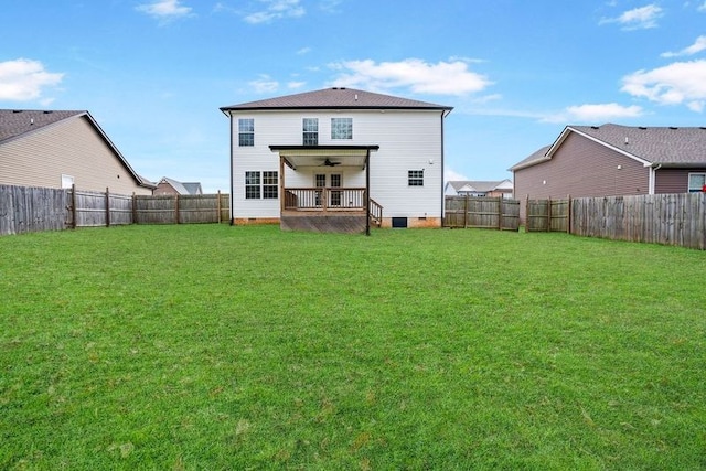 back of property featuring ceiling fan and a yard