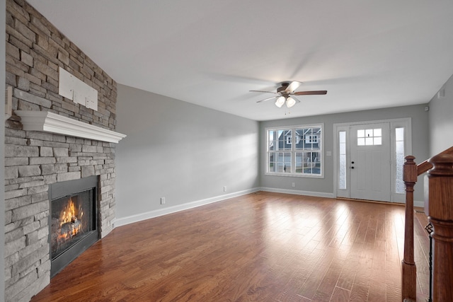 unfurnished living room featuring a stone fireplace, ceiling fan, and wood-type flooring