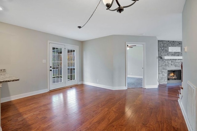 unfurnished living room featuring a fireplace, hardwood / wood-style floors, and a notable chandelier