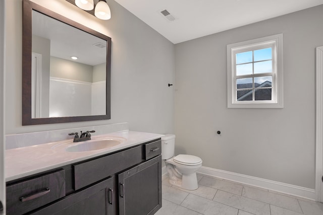 bathroom with tile patterned flooring, vanity, and toilet