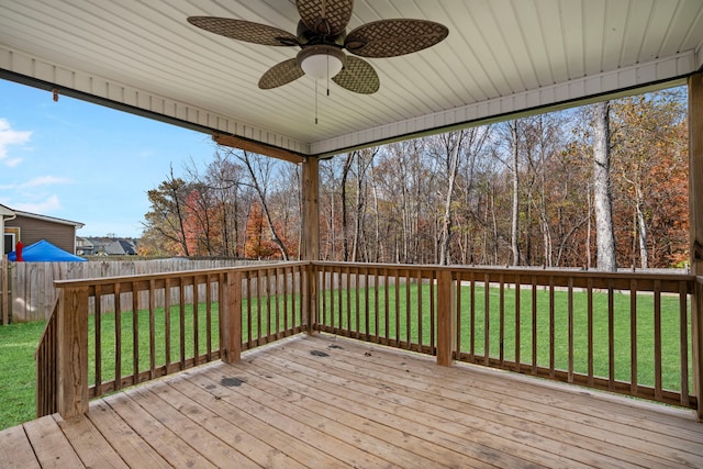 wooden terrace featuring a lawn and ceiling fan