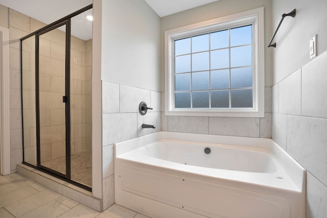 bathroom featuring tile patterned floors, tile walls, and plus walk in shower