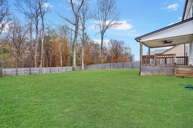 view of yard featuring ceiling fan and a deck