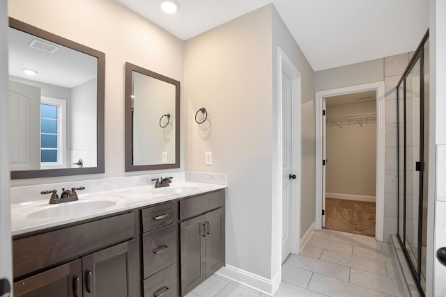 bathroom featuring tile patterned flooring, vanity, and a shower with door