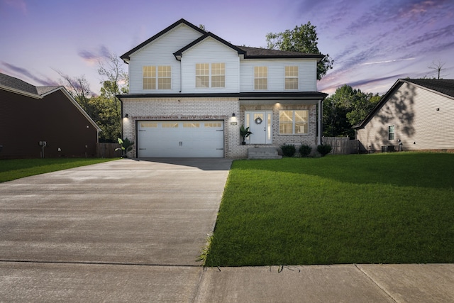 front facade featuring a garage and a lawn