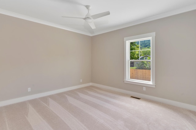 carpeted empty room with ceiling fan and ornamental molding