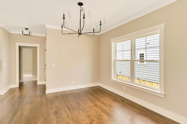 unfurnished dining area with a chandelier, wood finished floors, visible vents, baseboards, and crown molding