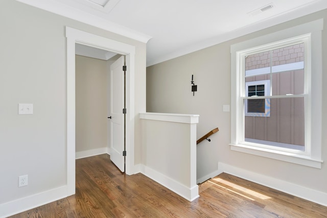 hall with hardwood / wood-style floors and crown molding