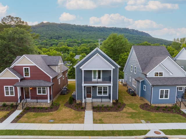 view of front of house featuring a porch, a balcony, and a front lawn