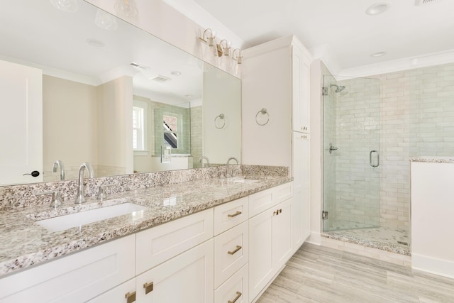 bathroom with hardwood / wood-style floors, vanity, an enclosed shower, and crown molding